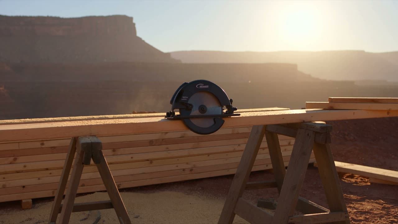 A work truck parked at a job site in early morning light with tools laid out on the tailgate